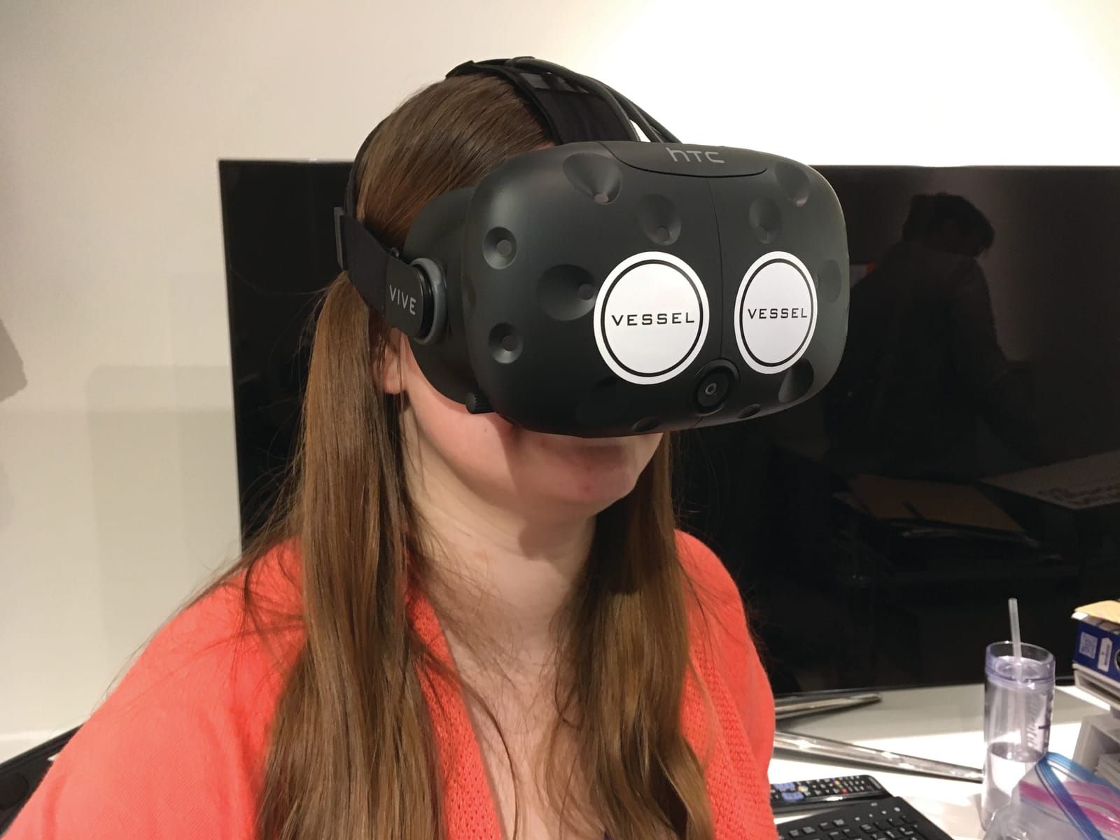 A Vessel team member wearing a VR headset marked with the Vessel logo