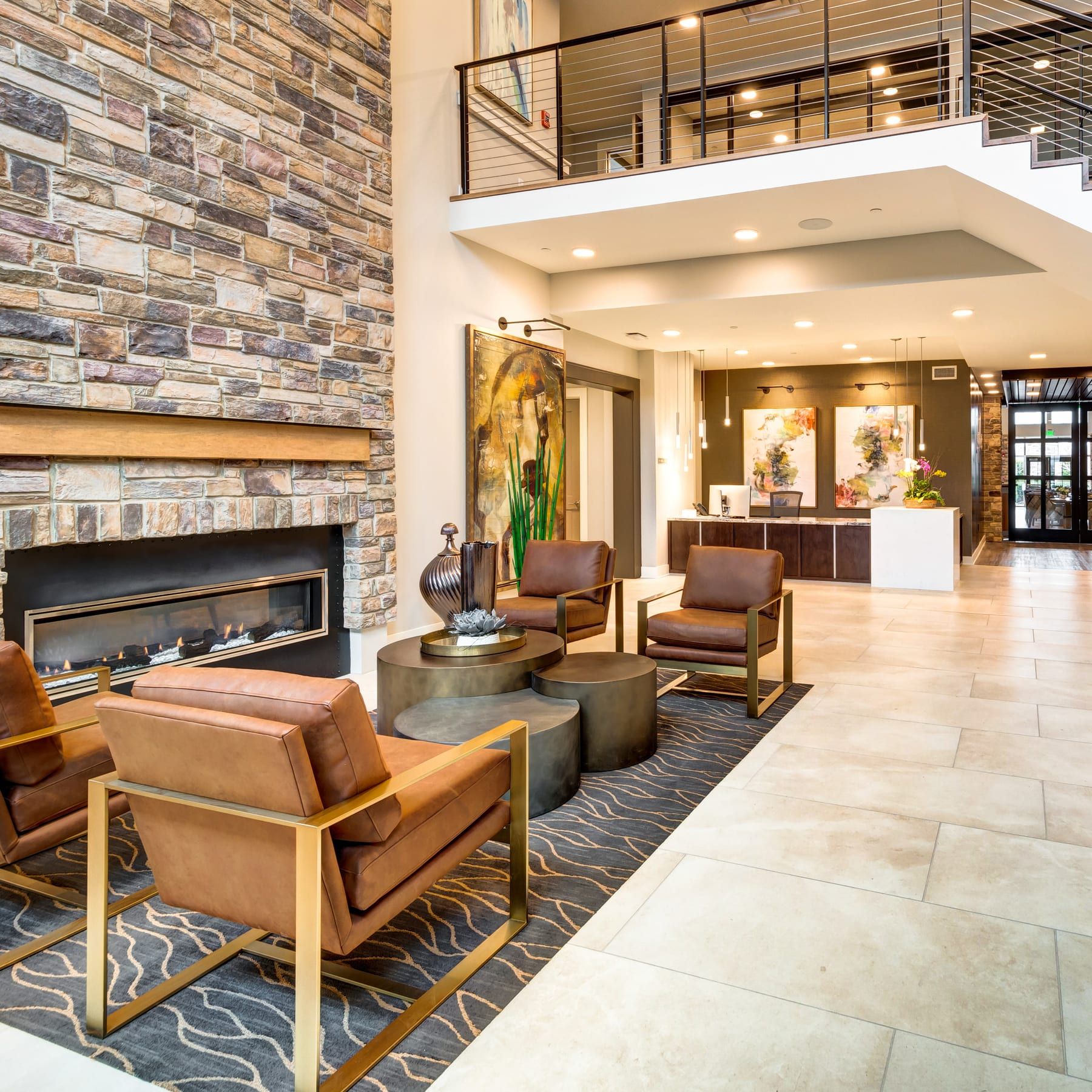 A photograph of the finished Algonquin lobby with a stone fireplace, a mezzanine and the reception desk